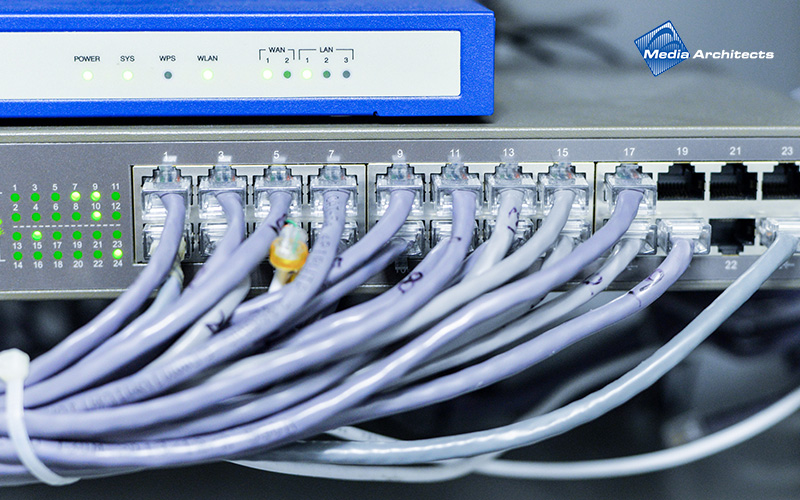 A network switch with numerous patch cables plugged in.