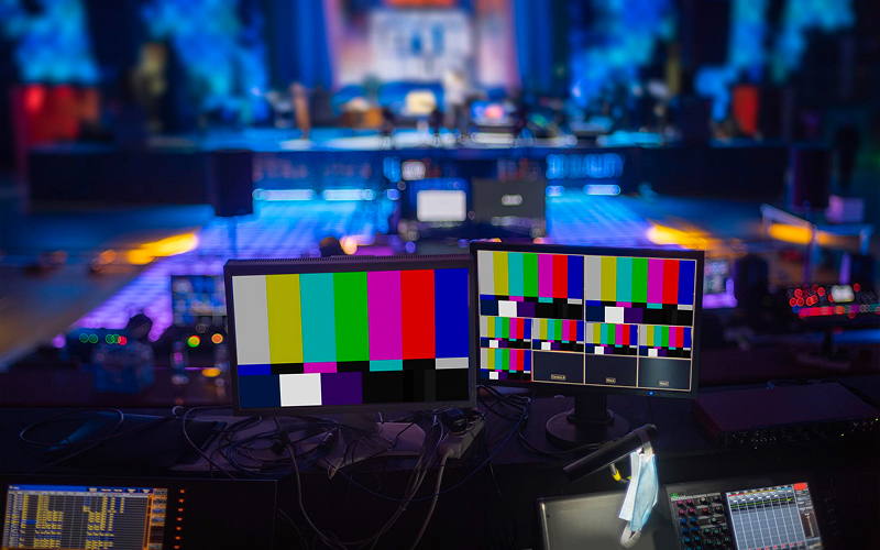 Multi-campus broadcast monitors displaying live service test patterns.