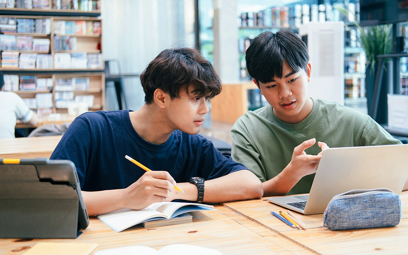 Students collaborating using laptops in a modern active-learning classroom.