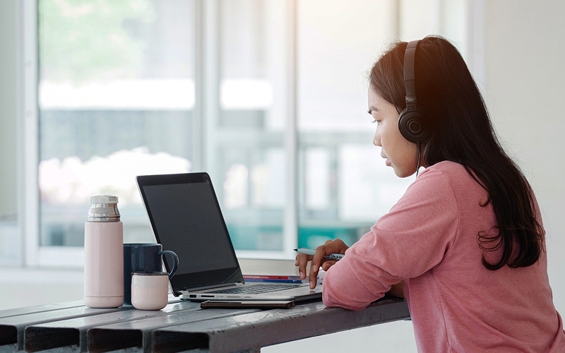 Student wearing headphones while studying in a digital classroom.